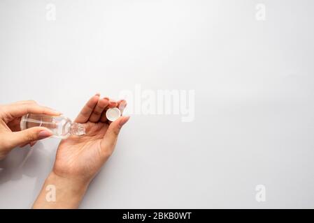 Verser le gel désinfectant sur les mains. Femme mains utilisant du gel de lavage à l'alcool pour nettoyer le distributeur de pompe de gel de désinfection sur fond bleu, concept de soins de santé. Protection contre les pandémies de coronavirus. Banque D'Images