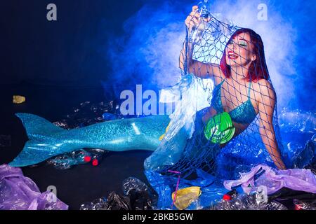 Fantasy stupide sirène dans les profondeurs de l'océan. Pollution des bouteilles et des sacs d'eau en plastique sur le fond marin. Problème environnemental. Banque D'Images
