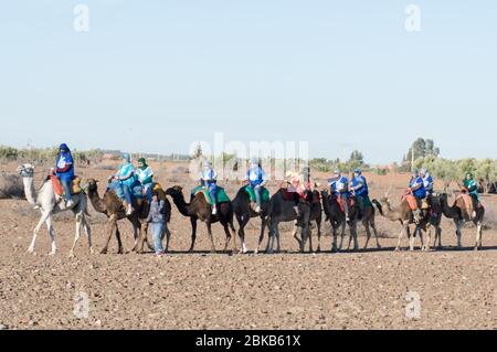 Groupe de touristes se préparer à un tour de chameau avec les vêtements traditionnels et couvrir la tête Banque D'Images