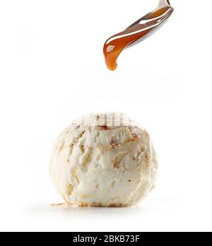 sauce caramel sur la pelle à glace en noyer isolée sur fond blanc Banque D'Images