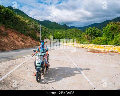 Une personne qui fait de la moto sur une route sinueuse en regardant la magnifique côte dans la province de Phu Yen, Nha Trang Quy Nhon, aventure en voyage au Viet Banque D'Images