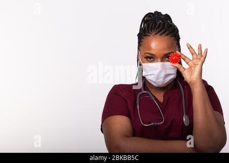 Covid-19, développement d'un vaccin, éclosion et médecine concept - Docteur en masque de protection médicale tenant un modèle de coronavirus sur fond blanc Banque D'Images