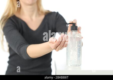 Gros plan de la femme appliquant du gel désinfectant pour les mains à partir du distributeur de bouteilles isolé sur fond blanc Banque D'Images