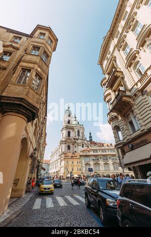 Vue sur l'église entre deux maisons de Prague contre le ciel bleu Banque D'Images