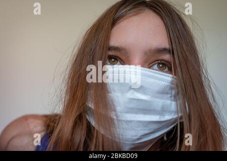 Le travailleur hospitalier portant un masque de protection, la jeune fille porte un masque qui protège contre la propagation de la maladie du coronavirus. Femme de gros plan avec un Banque D'Images