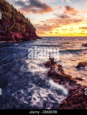 Lever du soleil devant la plage de sable rouge à Maui. Banque D'Images