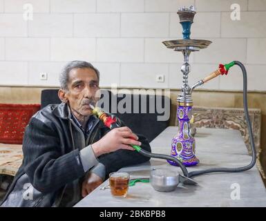 Homme âgé fumiant shisha dans Azari Chaykhaneh traditionnel (teahouse), Téhéran, Iran, Perse, Moyen-Orient Banque D'Images