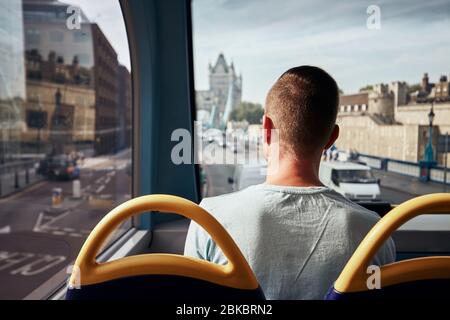 Homme voyageant en bus à impériale contre Tower Bridge. City Street à Londres, Royaume-Uni. Banque D'Images