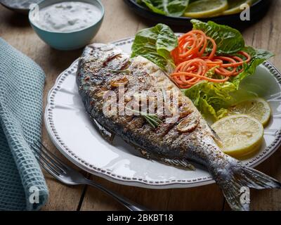 portion de poisson grillé sur table de cuisine en bois Banque D'Images