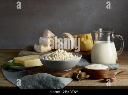 lait et divers produits laitiers sur une table de cuisine en bois Banque D'Images