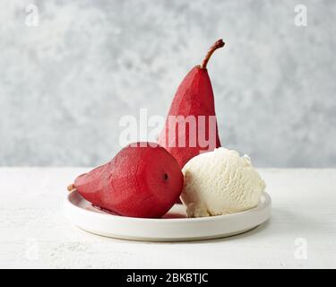 Poires pochées de vin rouge, dessert décoré de crème glacée Banque D'Images