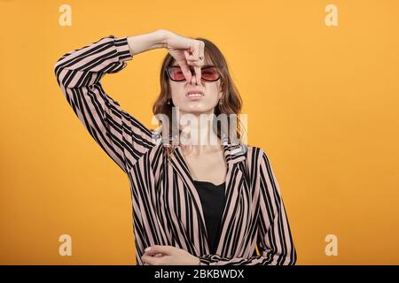 Fille dégoût visage de contorts à cause de mauvaise odeur, Stench, couvre nez avec la main Banque D'Images