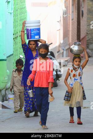 Beawar, Inde. 3 mai 2020. Une femme avec ses filles porte des pots remplis d'eau potable pendant le maintien à l'échelle nationale à la suite de la nouvelle pandémie de coronavirus (COVID-19), à Beawar. (Photo de Sumit Saraswat/Pacific Press) crédit: Agence de presse du Pacifique/Alay Live News Banque D'Images