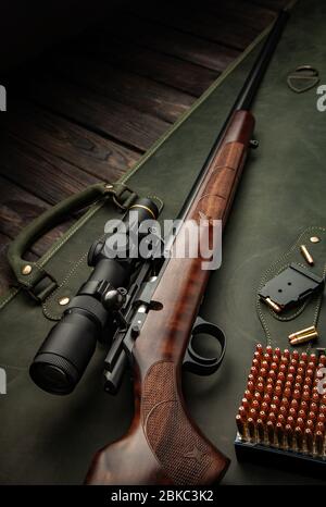 Boulonner le fusil de petit calibre 22 lr avec une vue optique sur un fond en bois. Chasse d'armes de petit calibre sur une table en bois. Banque D'Images