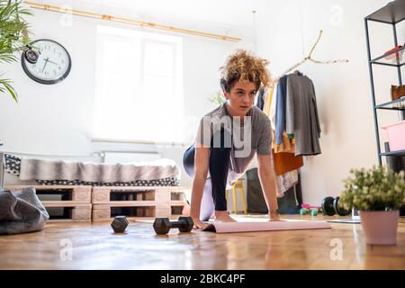 Jeune femme faisant de l'exercice de forme physique à la maison Banque D'Images