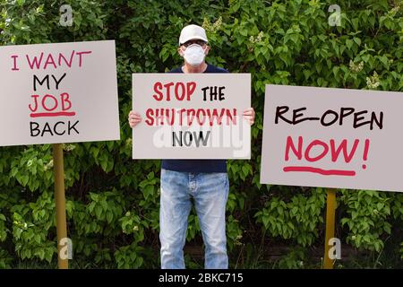 Le manifestant avec bouchon et masque de protection médicale se montre contre les commandes de séjour à domicile en raison de la pandémie COVID-19 avec signe indiquant Arrêt de l'arrêt Banque D'Images