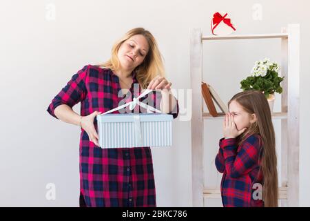 Adorable fille avec grande boîte cadeau le donnant à sa mère. Elle est présente. Concept de vacances, anniversaire et cadeaux. Banque D'Images