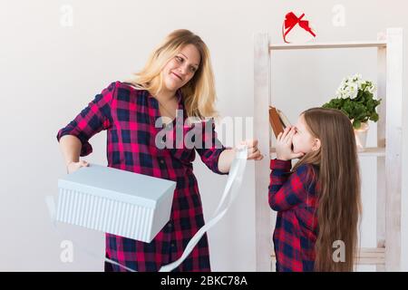 Adorable fille avec grande boîte cadeau le donnant à sa mère. Elle est présente. Concept de vacances, anniversaire et cadeaux. Banque D'Images