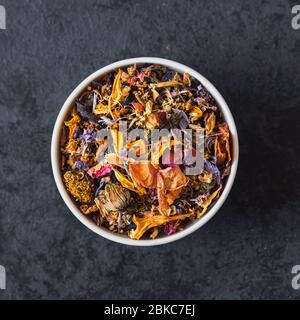 Mélanger le thé avec des fleurs séchées et des fruits secs. Banque D'Images