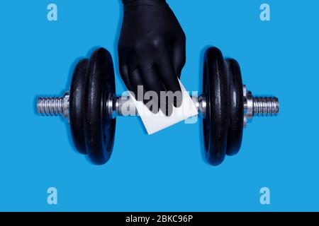 Coronavirus COVID-19 prévention dans le nettoyage de salle de sport équipement de sport Dumbell avec désinfection antibactérienne nettoyer essuyer contre le virus. Désinfection de l'équipement de fitness Banque D'Images