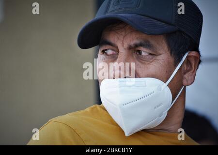 Homme hispanique d'âge moyen portant un masque pour covid 19 la mauvaise façon, en ne couvrant pas son nez en public dans une banque de Los Angeles Californie États-Unis Banque D'Images