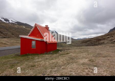 Chalet rouge sur la route 1 entre Reyðarfjörður et Egilsstaðir dans le nord-est de l'Islande. Banque D'Images