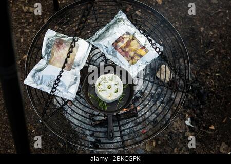 Cuisine sur un feu de camp sur un barbecue suspendu à Wowo's, un camping familial de Sussex Banque D'Images