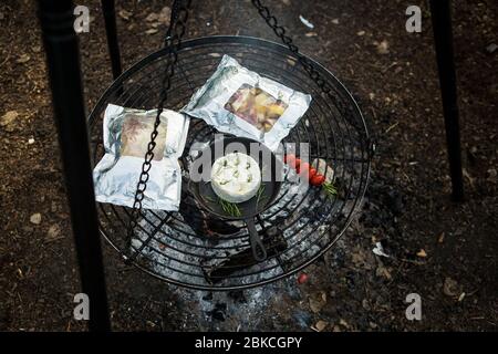 Cuisine sur un feu de camp sur un barbecue suspendu à Wowo's, un camping familial de Sussex Banque D'Images