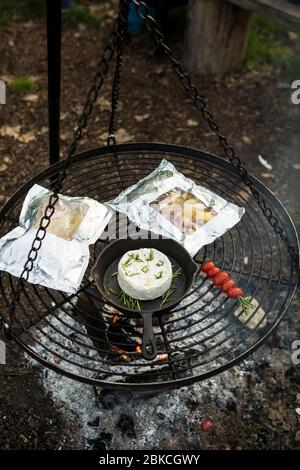 Cuisine sur un feu de camp sur un barbecue suspendu à Wowo's, un camping familial de Sussex Banque D'Images