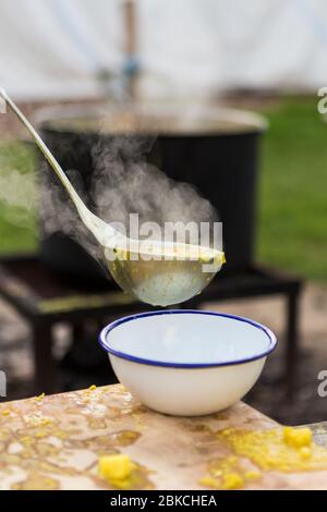 Soupe gratuite cuite sur le feu de camp, servie en soirée d'été à Wowo's, un camping familial dans le Sussex Banque D'Images