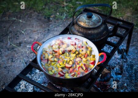 Ragoût de rhubarbe pour le désert cuit à l'extérieur sur un feu ouvert pendant le camping dans le Kent, Royaume-Uni Banque D'Images