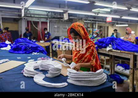 Le travail de Laborer dans une usine de vêtements, alors que les usines ont rouvert après que le gouvernement a assoupli les restrictions en raison des préoccupations concernant la maladie du coronavirus (COVID-19) flambée à Dhaka, au Bangladesh, le 03 mai 2020. Banque D'Images