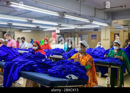 Le travail de Laborer dans une usine de vêtements, alors que les usines ont rouvert après que le gouvernement a assoupli les restrictions en raison des préoccupations concernant la maladie du coronavirus (COVID-19) flambée à Dhaka, au Bangladesh, le 03 mai 2020. Banque D'Images