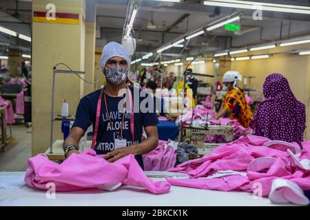 Le travail de Laborer dans une usine de vêtements, alors que les usines ont rouvert après que le gouvernement a assoupli les restrictions en raison des préoccupations concernant la maladie du coronavirus (COVID-19) flambée à Dhaka, au Bangladesh, le 03 mai 2020. Banque D'Images