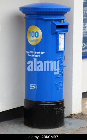 Une Postbox bleue à l’extérieur du bureau de poste de village de Marson Morelaine.Royal Mail a célébré le 100ème anniversaire du capitaine Tom Moore avec une boîte postale spéciale en l’honneur de ses efforts incroyables pour recueillir de l’argent pour le NHS (Services nationaux de santé). La boîte postale est peinte en bleu NHS et comprend un ballon d'or et des voeux d'anniversaire. Son fantastique effort de collecte de fonds a atteint la note de 32 millions de livres sterling pour le NHS, et il est devenu un symbole d'espoir et d'unité à travers le Royaume-Uni et au-delà pendant ces périodes incertaines. Banque D'Images