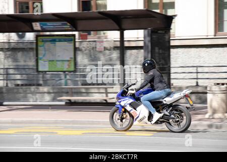 Belgrade, Serbie - 23 avril 2020: Une jeune femme qui monte une moto rapide dans une rue de ville vide Banque D'Images