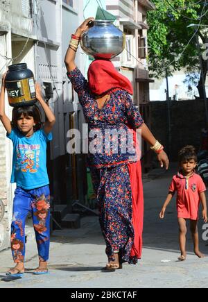 Beawar, Inde. 3 mai 2020. Une femme avec sa fille porte des pots remplis d'eau potable pendant le maintien à l'échelle nationale à la suite de la nouvelle pandémie de coronavirus (COVID-19), à Beawar, en Inde, le 3 mai 2020. (Photo de Sumit Saraswat/Pacific Press/Sipa USA) crédit: SIPA USA/Alay Live News Banque D'Images