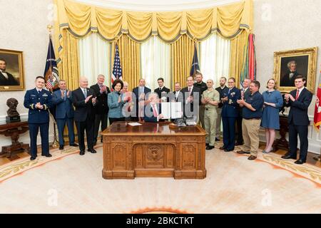 Le président Donald J. Trump, accompagné de la secrétaire aux Transports Elaine Chao, à gauche, et invité les invités, signe un décret exécutif « soutenant la transition des militaires et des membres du service de service actif vers les marines du marchand » le lundi 4 mars 2019, au Bureau ovale de la Maison Blanche. Le président Trump signe un ordre exécutif « soutenant la transition des membres du service actif et des anciens combattants militaires vers les marines du marchand » Banque D'Images