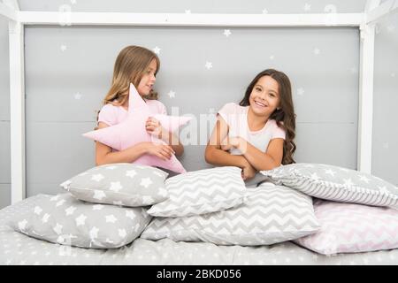 Bonne enfance. Les enfants heureux s'amusent au lit. Les petites filles jouent avec des coussins. Profiter des années d'enfance. Protection de l'enfance. Centre de garde d'enfants. Journée pour les enfants. L'enfance ne se produit qu'une seule fois. Banque D'Images