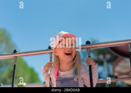 Gros plan portrait de Happy blond 4 ans fille jouant sur le terrain de jeu en plein air Banque D'Images