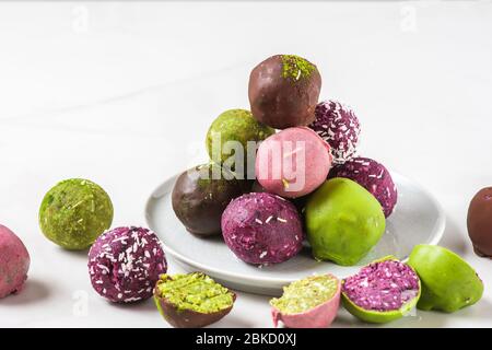 Délicieux desserts végétaliens. Cookies crus à base de noix biologiques, dattes, matcha, acai et baies dans le chocolat glacer. Des collations saines Banque D'Images