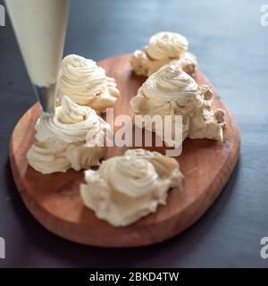 Le processus de création de dessert Pavlova, décorant la meringue avec la crème Banque D'Images