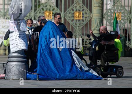 Une vue montre certaines personnes qui protestent contre le verrouillage avec une occupation illégale dans Turin déserte sur la Piazza Castello le 3 mai en Italie, du Banque D'Images