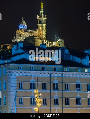 Basilique lumineuse de notre Dame de la Garde surplombant le vieux port de Marseille la nuit, France Banque D'Images