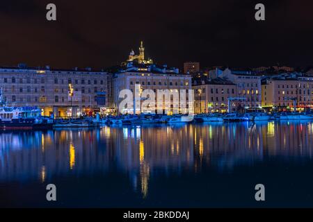 Paysage urbain du Vieux Port de Marseille (vieux port) la nuit avec la basilique notre Dame de la Garde en arrière-plan Banque D'Images