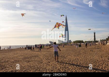 Saint-Pétersbourg, Russie - 31 août 2019. Les gens marchent autour, des rubans colorés et des figurines en cerf-volant accrochés sur des poteaux et volant dans le ciel bleu Banque D'Images