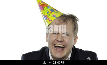 Portrait de l'homme de jeune employée endormi avec un hangover rires. Émotions. Homme d'affaires en costume et casquette festive avec bouée. Fond blanc. Concept de fête d'anniversaire de bureau Banque D'Images