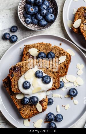 Tranches de pain à la banane avec baies et yaourt sur une assiette grise. Concept de nourriture végétarienne saine. Banque D'Images