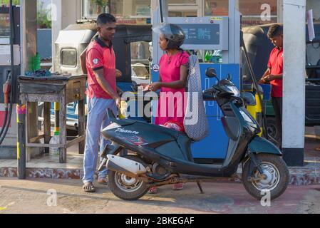 TRINCOMALEE, SRI LANKA - 11 FÉVRIER 2020 : une fille sri-lankaise paie pour faire le plein d'un scooter sur une station-service Banque D'Images