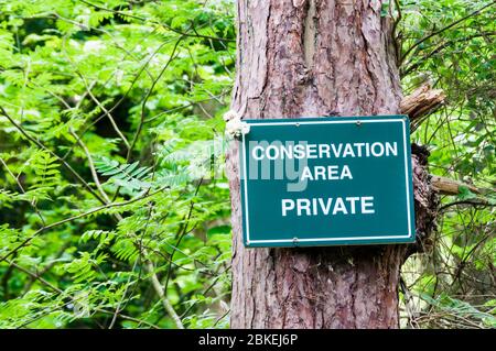 Zone de conservation, privée, panneau fixé à un arbre dans une zone forestière pour protéger une zone réservée à la conservation de la faune. Banque D'Images